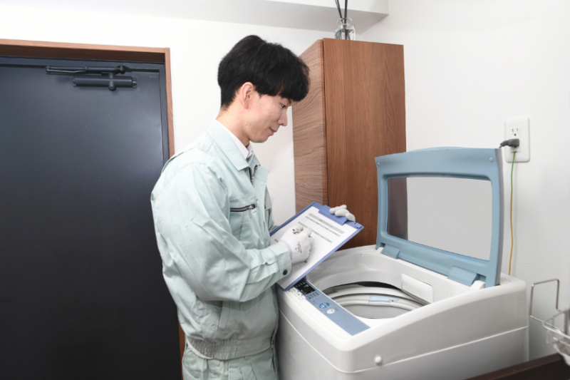 洗濯機を点検する業者